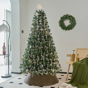 Large pre-lit Christmas tree decorated with snowflakes and icicles in a cozy home setting