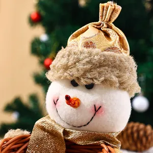 Close-up of a festive Christmas snowman head with golden hat on a wicker fruit basket.