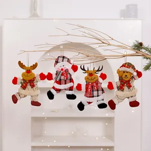 Detailed view of four Christmas fabric plush ornaments hanging from a decorative branch
