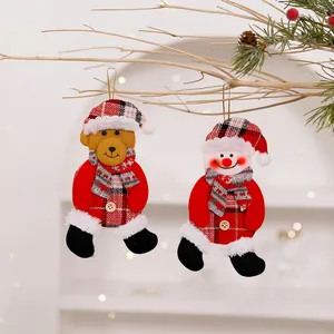 Close-up of Christmas fabric ornaments featuring a bear and snowman on a branch