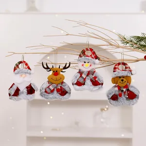 Close-up of four plush Christmas ornaments including Santa and Reindeer on a branch