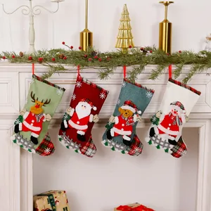 Four linen Christmas stockings with Santa, snowman and reindeer hanging on a mantel