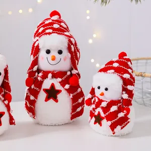 Vista detallada de adorables muñecos de nieve de peluche con gorros rojos