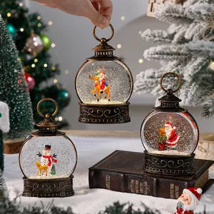 Detailed view of bronze Christmas lantern snow globes with Santa and snowman scenes