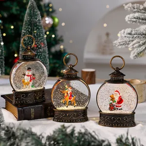 Close-up of three vintage Christmas water-filled lanterns with Santa and snowman motifs