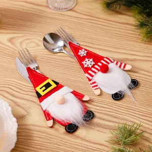 Detailweergave van feestelijke kerstbestekhouders met kabouters op een houten tafel