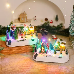 Detailansicht von zwei leuchtenden Weihnachtsmanndorf-Spieluhren mit LED-Beleuchtung