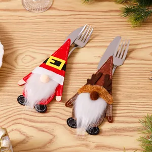 Detail van feestelijke kerstman en rendier kabouter bestekhouders op een houten tafel