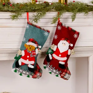 Detail showing linen Christmas stockings with 3D Santa and bear motifs on fireplace.