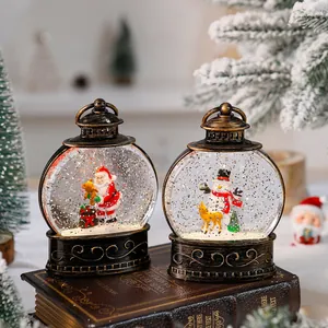 Detailed view of Christmas snow globe lanterns with Santa and snowman on a vintage book