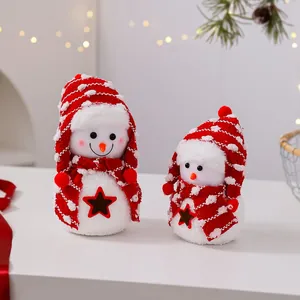 Primer plano de dos lindos muñecos de nieve de peluche con gorros y bufandas rojas de Navidad.