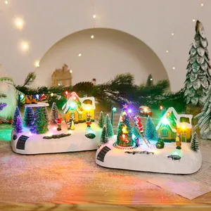 Detailaufnahme von leuchtenden Weihnachtsdorf-Ornamenten mit rotierendem Zug und Lichtern