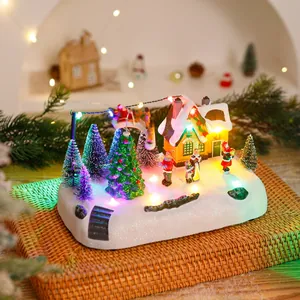 Detailansicht einer leuchtenden Weihnachtsspieluhr mit Schneehaus und Nikolausfiguren