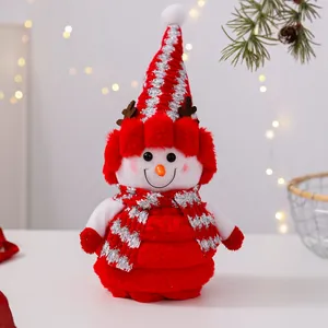 Primer plano de un lindo muñeco de nieve de peluche con traje festivo rojo y plateado.