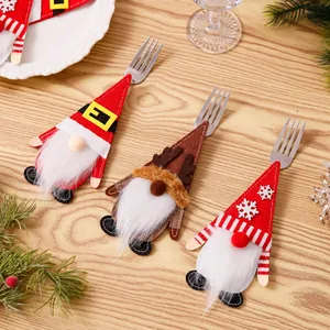 Detailweergave van drie feestelijke kerstkabouter bestekhouders op een houten tafel