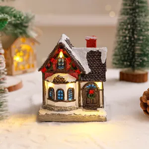 Vista dettagliata di una casa di Natale in miniatura con calde luci LED e tetto innevato