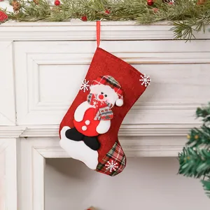 Calcetín navideño de arpillera roja con muñeco de nieve 3D en una chimenea blanca