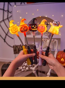 Detail of glowing Halloween wands with pumpkin and ghost designs held in hands.
