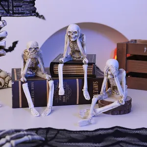 Detailed view of resin Halloween skeletons with dangling legs on decorative books