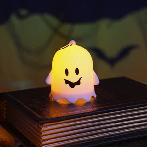 Close-up of a cute glowing ghost night light on an antique book for Halloween