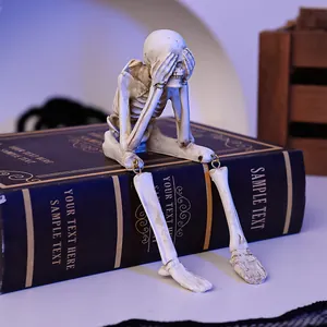 Detailed view of a resin skeleton Halloween ornament sitting on a prop book.