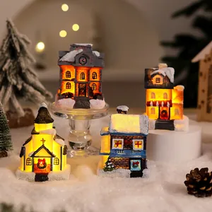 Close-up of glowing miniature resin snow houses for Christmas village decoration