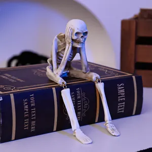Detailed view of a Halloween resin skeleton figurine sitting on a decorative book.