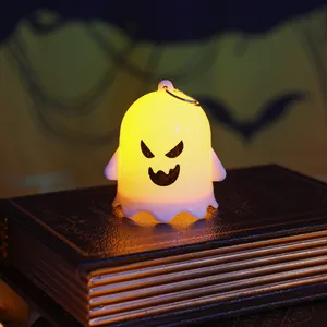 Close-up of a glowing ghost night light on vintage books for Halloween decor.