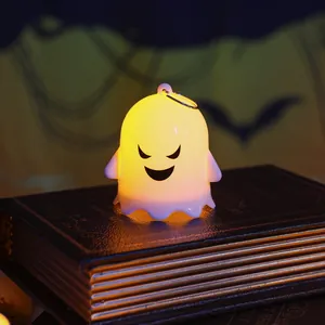 Detailed view of glowing Halloween ghost night light ornament on decorative vintage books