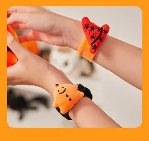 Detail van schattige pluchen Halloween-polsbandjes met pompoen en heksenhoed voor kinderen