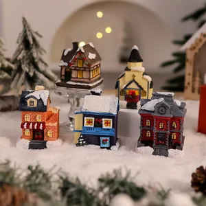Collection of miniature resin Christmas village houses with snowy roofs and festive details