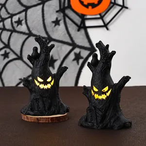 Nahaufnahme von gruseligen leuchtenden Halloween-Baumstumpf-Dekorationen mit RIP-Grabsteinen.
