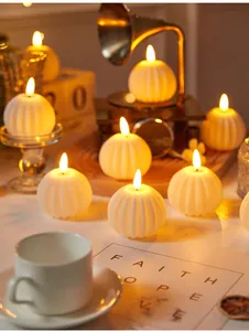Atmospheric warm lighting from multiple pumpkin shaped LED electronic candles on a table