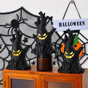 Detailansicht von Halloween-Geisterbaumstümpfen mit leuchtenden Gesichtern und Grabsteinen.
