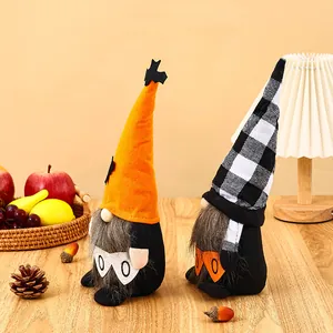 Close-up of Halloween gnomes with orange and plaid hats on a cozy wooden table decor