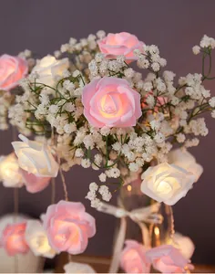 Nahaufnahme von rosafarbenen und weißen LED-Rosen-Lichterketten mit warmem Licht