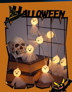 Close-up of Halloween LED ghost string lights with tulle skirts on vintage books.