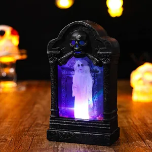 Detailed view of a glowing Halloween tombstone lamp featuring a ghost and skull motif.