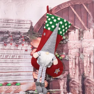 Close-up detail of a festive red Christmas stocking with a 3D grey plush gnome decoration