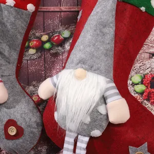 Detail of festive Christmas stocking featuring a gray gnome and felt heart decoration