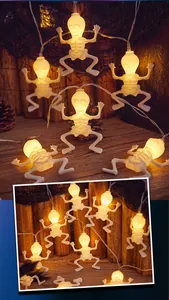 Close-up of Halloween LED skeleton string lights with warm yellow glow on wooden background