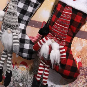 Detailed macro view of red and black buffalo plaid Christmas stockings with plush gnomes