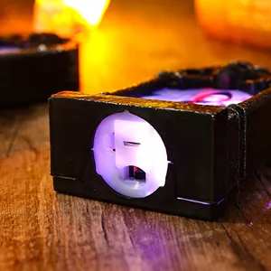 Detail of the battery compartment and switch on a light-up Halloween tombstone
