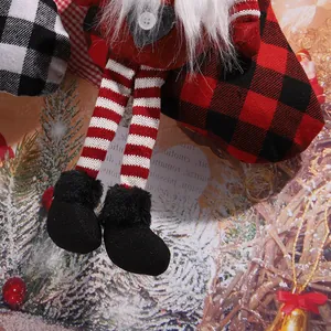 Close-up of red and black buffalo plaid Christmas stocking with long striped legs