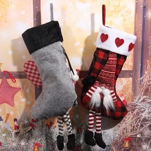 Detailed view of red black plaid Christmas stocking with gnome and striped hanging legs