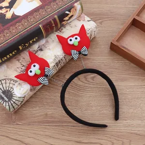 Detalle de diadema de Halloween con monstruos rojos y lazos sobre mesa de madera