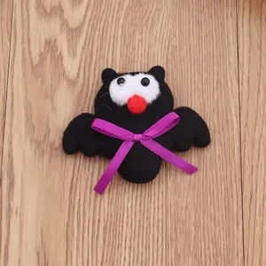 Gedetailleerd overzicht van pluche Halloween vleermuisbroche met een paars lintdecor