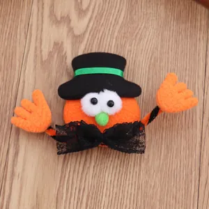 Close-up van een schattige handgemaakte Halloween pompoen broche met een zwarte hoge hoed.