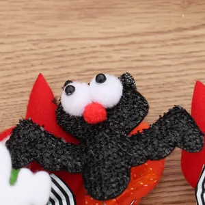 Primer plano de un murciélago negro brillante con ojos grandes en una diadema de Halloween festiva.