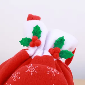 Festive red Christmas gift bag with snowflake prints and 3D holly berry pompom details.